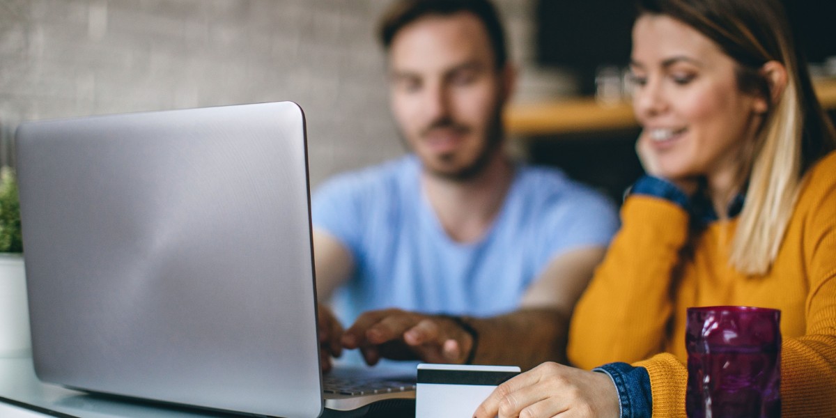 Young couple online shopping together on their laptop.
