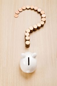 price-dollar Piggybank facing stacks of pennies arranged into a question mark.