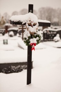 Snow covered cross in a cemetery.