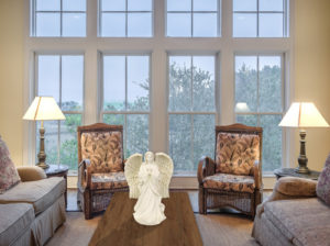 White angel statue sitting on the table in a living room.