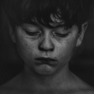 Photo Young boy with tears running down his cheeks.