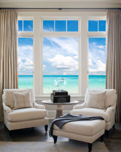 Circle of Love Dolphin Lucite Art Cremation Urn on table near window with sea view.
