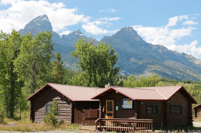 Wood cabin in the valley beneath the mountains.