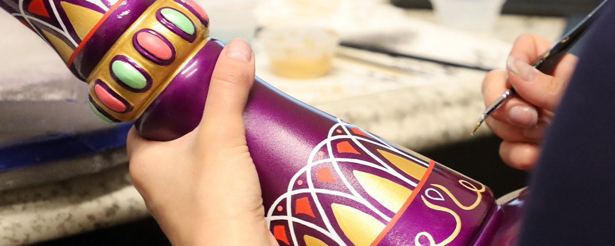 The 3D-printed genie bottle custom urn being painted by hand.