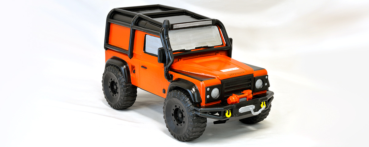 A 3D-printed custom cremation urn that looks like a bright orange Land Rover.