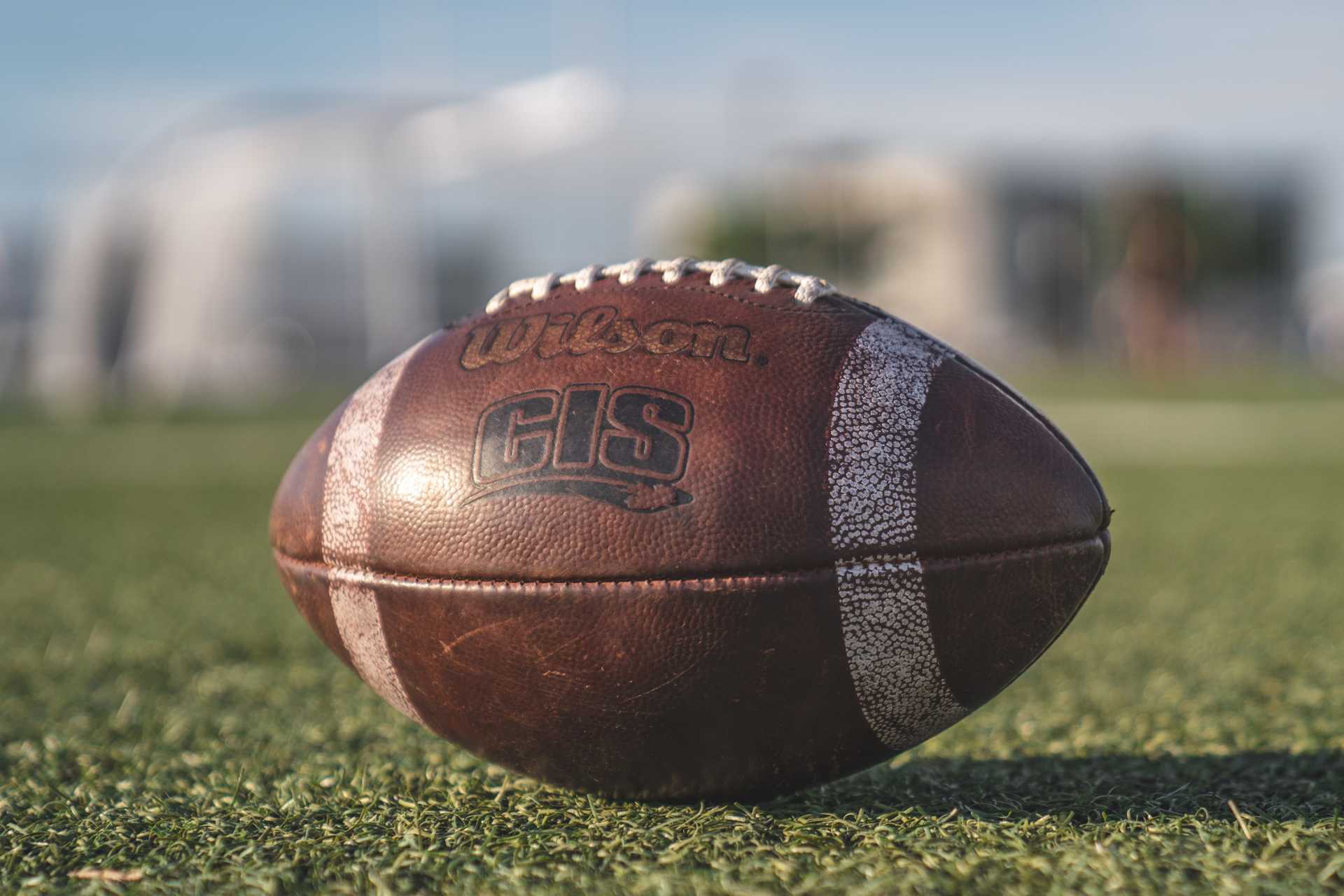 Wilson GIS football sitting atop a turf field.