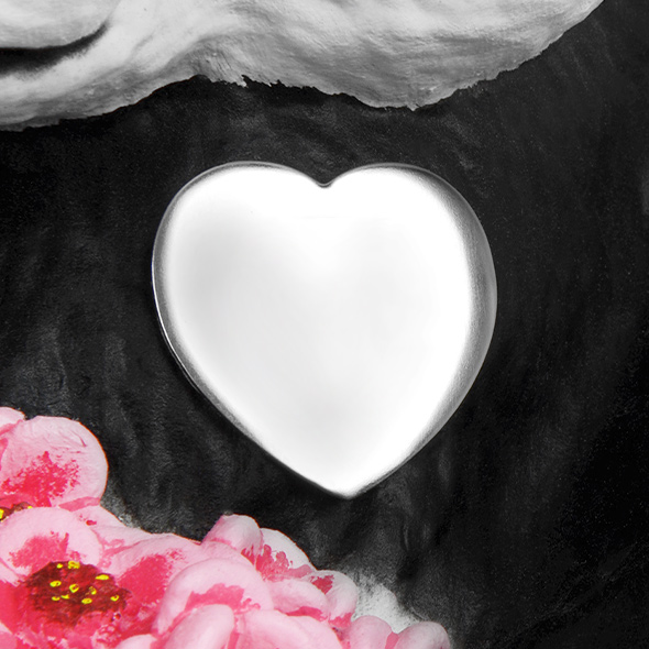 A close-up of the silver heart medallion on the panda's chest to be engraved.