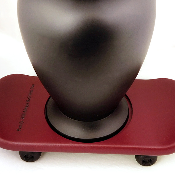The 3D-printed skateboard urn base holding a black urn.