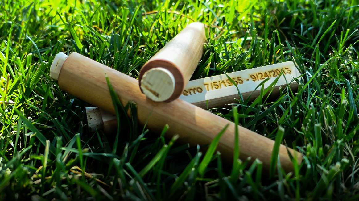 Wood cremains scattering tubes in the grass.